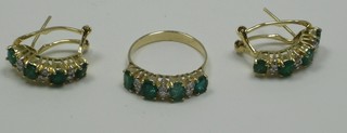 A suite of gold jewellery comprising half eternity dress ring set emeralds and diamonds together with a pair of matching half hoop earrings, marked 750
