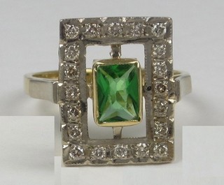 A lady's rectangular dress ring set a green stone surrounded by diamonds