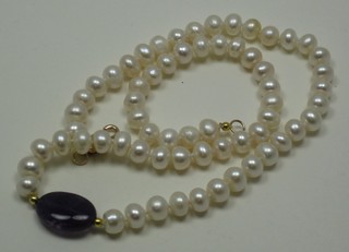 A rope of fresh water pearls set an amethyst