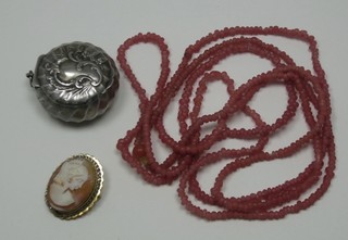 A string of coral beads, a shell carved cameo brooch and a small silver plated compact