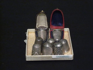 2 thimbles contained in silver cases and 6 others