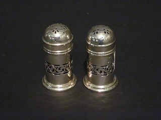 A pair of cylindrical pierced Sterling pepperettes with blue glass  liners