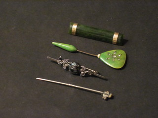A jade coloured rectangular brooch with gilt metal mounts, a jade  coloured stick pin, 1 other stick pin and a brooch