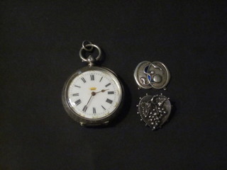 An open faced fob watch contained in a silver case, a brooch etc