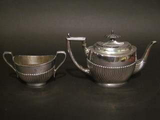 An oval Britannia metal teapot with demi-reeded decoration  and matching sugar bowl