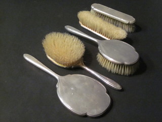 A 5 piece silver backed dressing table set comprising pair of hair brushes, pair of clothes brushes and a hand mirror