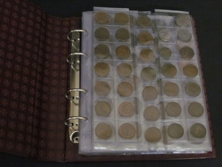 A red loose leaf album of various coins