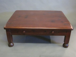 An Eastern rectangular hardwood coffee table fitted 2 drawers, raised on square supports ending in bun feet 47"