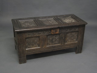 A 17th/18th Century carved oak coffer of panelled construction, the interior fitted a candle box and with iron hasp 42"