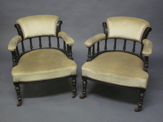 A pair of Edwardian ebonised tub back chairs upholstered in  mushroom material, raised on turned supports