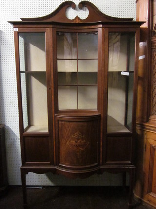 An Edwardian inlaid mahogany display cabinet, the upper section  with broken pediment, the interior fitted shelves enclosed by  panelled doors, raised on square tapering supports, 1 leg missing,  old worm to plywood back, 43"