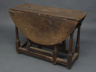 A 17th/18th Century oak dropflap gateleg dining table, raised on  turned and block supports 40"