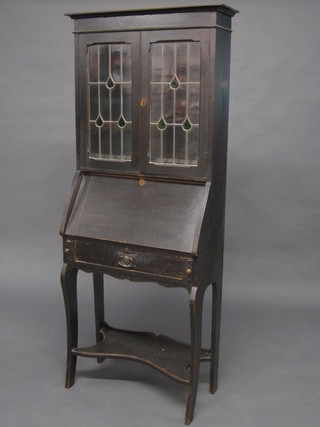An Art Nouveau oak student's bureau bookcase, the upper section fitted shelves enclosed by lead glazed panelled doors, the  fall front revealing a fitted interior above a drawer, raised on  cabriole supports