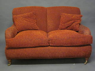 A Victorian style mahogany framed 2 seat settee upholstered in red material, raised on turned supports, 54"