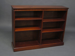 A mahogany bookcase with moulded cornice, the interior fitted adjustable shelves, raised on a platform base 48"