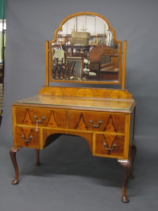 A 1930's Queen Anne style walnut dressing table with arched  plate mirror to the back and crossbanded top, fitted 2 long and 2  short drawers on cabriole supports 42"