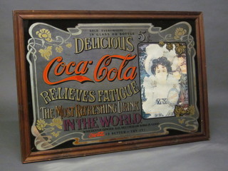A reproduction Coca Cola advertising mirror contained in an oak frame 24" x 35"