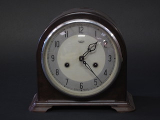 A Smiths 8 day mantel clock with silvered dial and Arabic  numerals contained in an arched brown Bakelite case