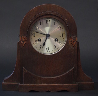 A 1930's 8 day striking mantel clock with silvered dial and Arabic numerals contained in an oak arch shaped case