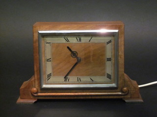 An Art Deco electric mantel clock with square dial and Roman  numerals contained in a walnut case
