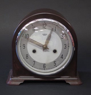 An Art Deco mantel clock with silvered dial and Arabic numerals contained in an arch shaped Bakelite case