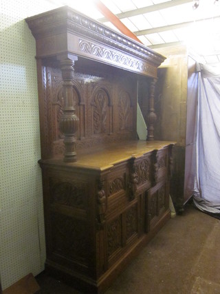 A Victorian carved honey oak sideboard with raised back, the  base fitted a double cupboard above 2 double cupboards, 63"