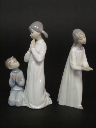 A Lladro figure of 2 children in prayer, base incised 479 8" and  1 other Lladro figure of a girl with arms outstretched 8", chip to  foot,