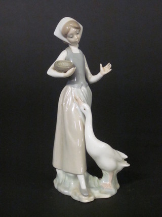 A Lladro figure of a standing lady with goose 9"