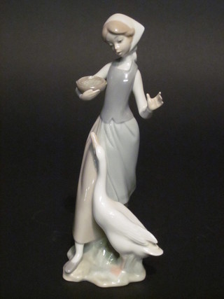 A Lladro figure of a standing girl with geese 9"