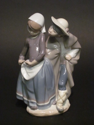 A Lladro figure of a standing boy and girl 8"