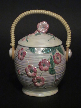 A circular Malingware biscuit barrel and cover with floral  decoration