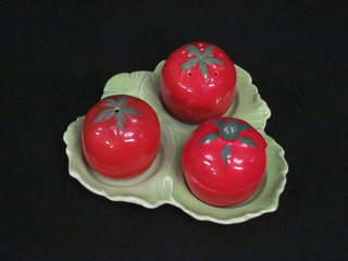 A 3 piece Malingware condiment set in the form of tomatoes, raised on a shaped base