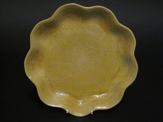 An Oriental yellow scallop shaped dish decorated a dragon, the base with 6 character mark, f and r, 9"  ILLUSTRATED