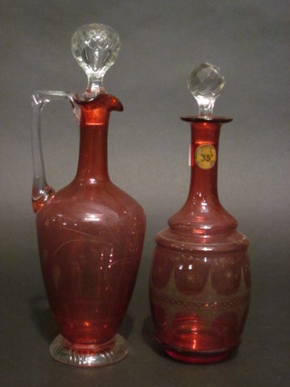 A 19th Century French etched red glass club shaped decanter decorated the Eiffel Tower marked 35th degree, 11", together  with a cranberry glass ewer and stopper with clear glass handle  13"