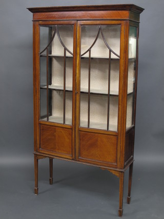 An Edwardian inlaid mahogany display cabinet with moulded  cornice, the interior fitted shelves enclosed by astragal glazed  panelled doors, raised on square tapering supports ending in  spade feet, 37"