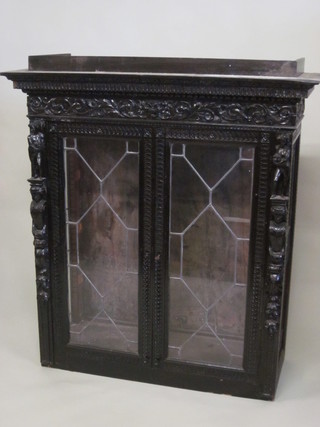 A Victorian oak display cabinet, heavily carved throughout and  enclosed by lead glazed doors 49"