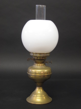 A brass oil lamp with clear glass shade and glass chimney