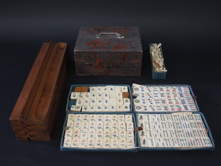A bone and bamboo Mahjong set contained in a pokerwork  wooden box with hinged lid together with 4 wooden walls