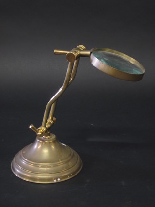 A brass and glass table magnifying glass and stand