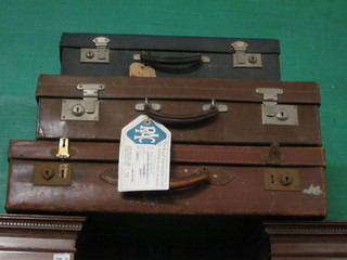 A brown leather suitcase with chrome fittings 26" x 15", a  rectangular brown leather vanity case 24" x 15" and a green  leather vanity case 20" x 30"
