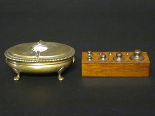 An 18th Century oval gilt metal twin section incense boat with hinged lid, raised on paw feet 5" together with 9 brass weights  contained in an oak stand