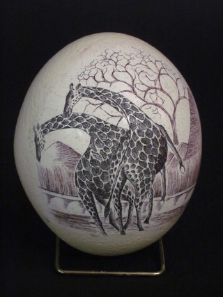 A carved ostrich egg decorated giraffes 6"