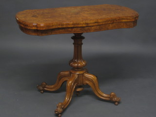 A Victorian shaped figured walnut card table of serpentine outline, raised on a turned column 37"