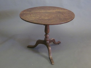 An 18th/19th Century circular oak snap top tea table, raised on a column and tripod base 32"