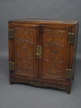 An Oriental hardwood cabinet enclosed by panelled doors, 32"