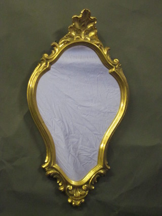 A shaped plate mirror contained in a decorative gilt frame 21"