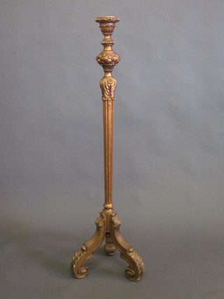 A carved and fluted gilt painted torchere