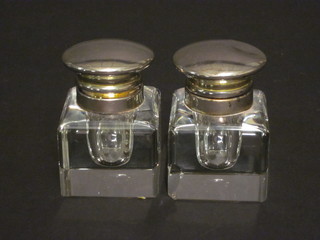 A pair of square cut glass inkwells with silver plated lids 2"