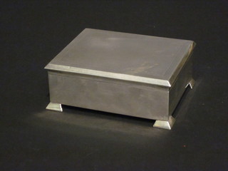A silver cigarette box with engine turned decoration, raised on bracket feet, Chester 1928, 4 1/2"  ILLUSTRATED