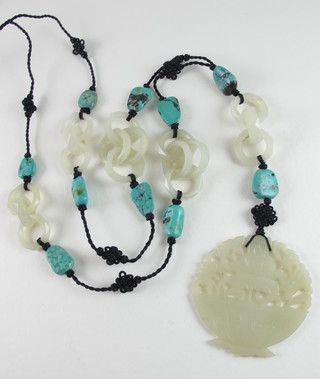 A carved Eastern interspaced hardstone jade coloured necklace hung a hardstone pendant